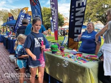  Image of two young girls having fun selecting giveaways at Newark Community Day